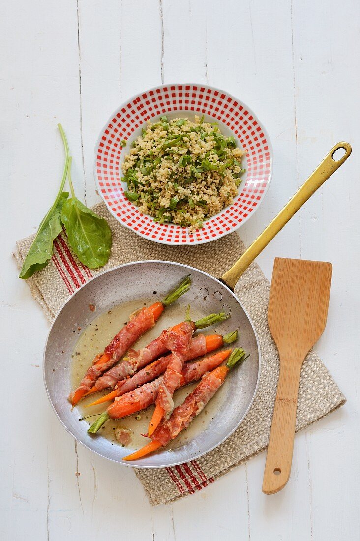 Carrots wrapped in ham served with couscous with sorrell