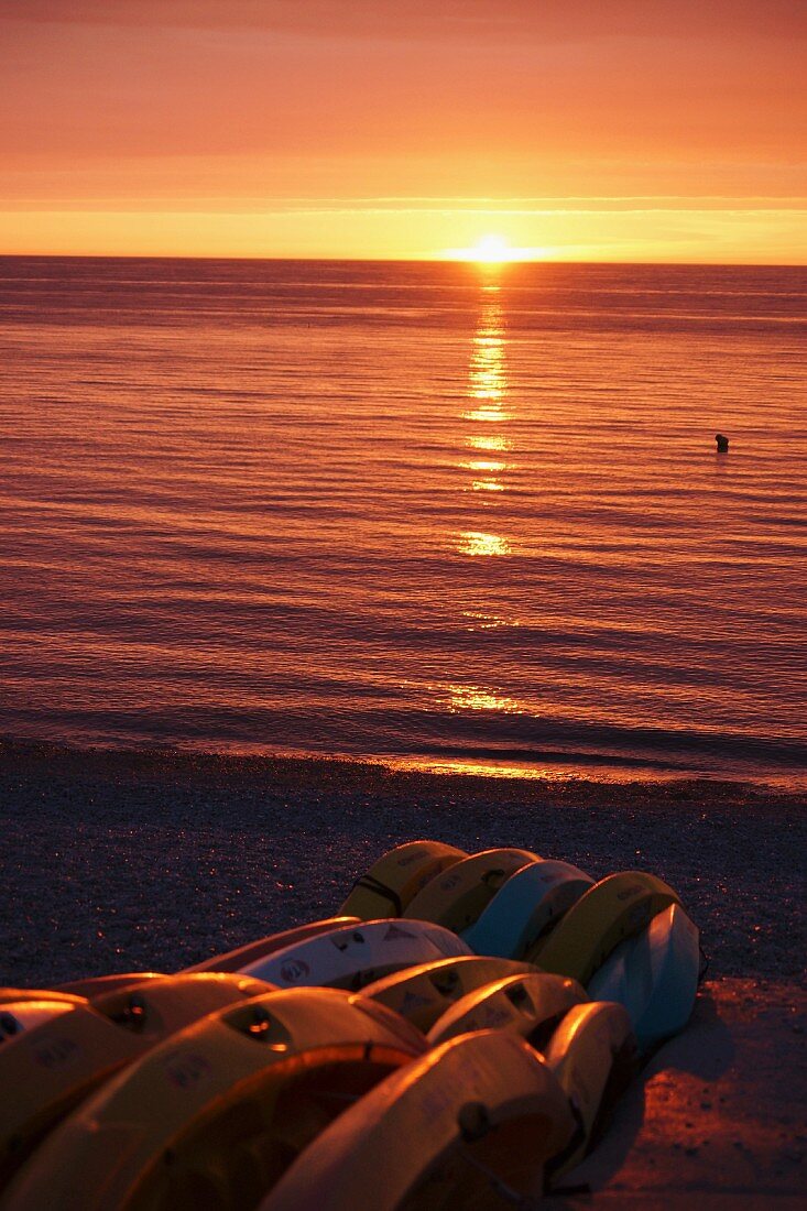 Romantic ocean sunset with boats on shore