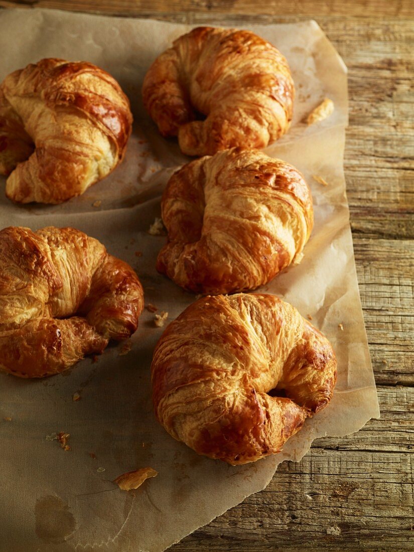 Croissants auf Backpapier auf Holztisch