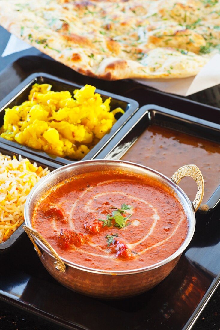 Hähnchen Tikka Masala mit Currykartoffeln, Reis, Linsen und Naan (Indien)