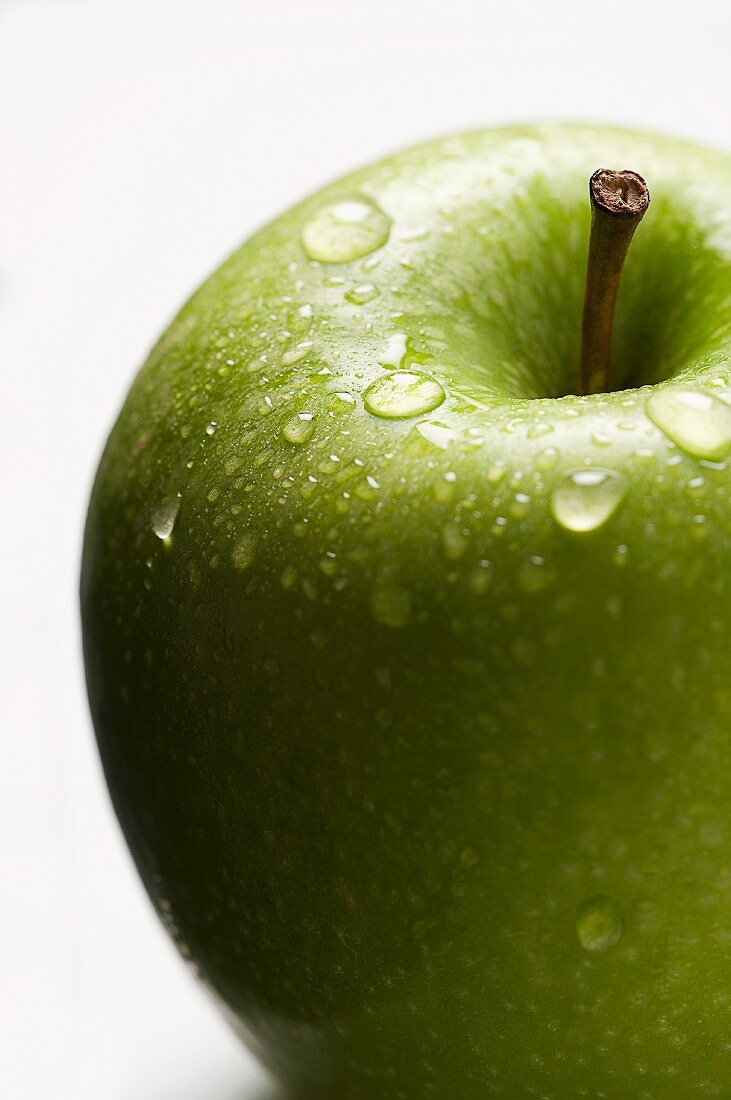Ein grüner Apfel mit Wassertropfen