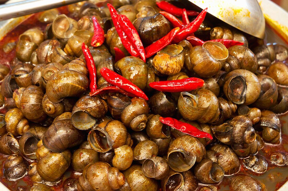 Schnecken mit Chili auf einem Markt in Lijiang, China