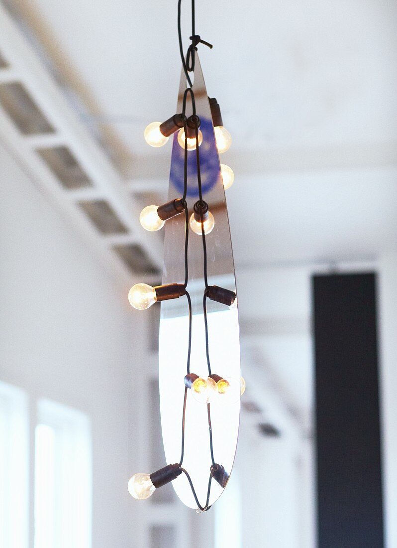 Hand-crafted pendant lamps with metal teardrop amongst light bulbs