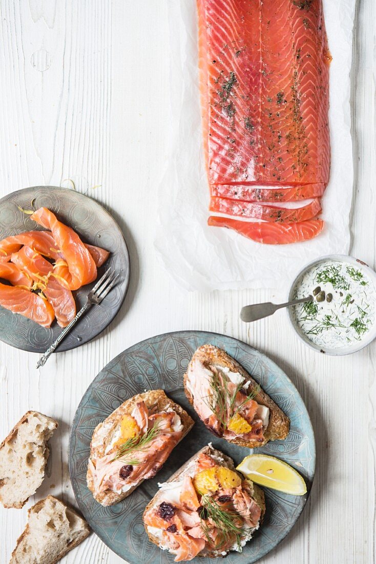 A side of smoked salmon, smoked salmon strips and salmon served on bread