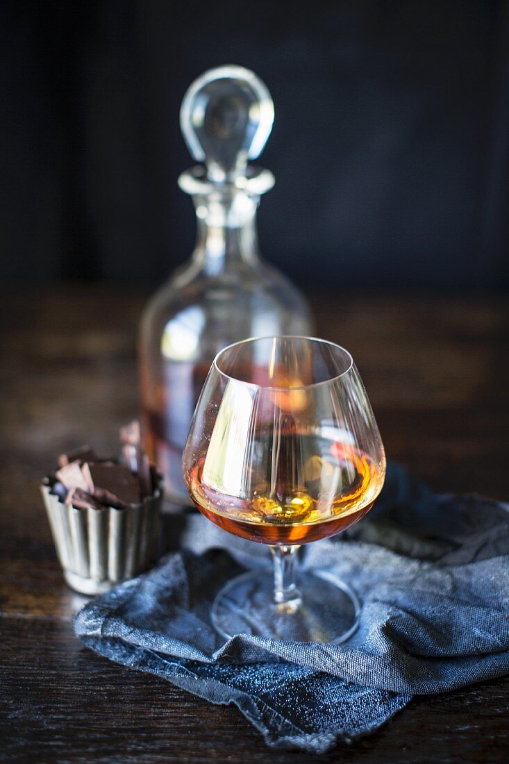 Brandy in a glass and the carafe with chocolate pralines