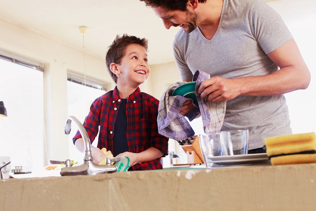 A father and son working happily together in the kitchen