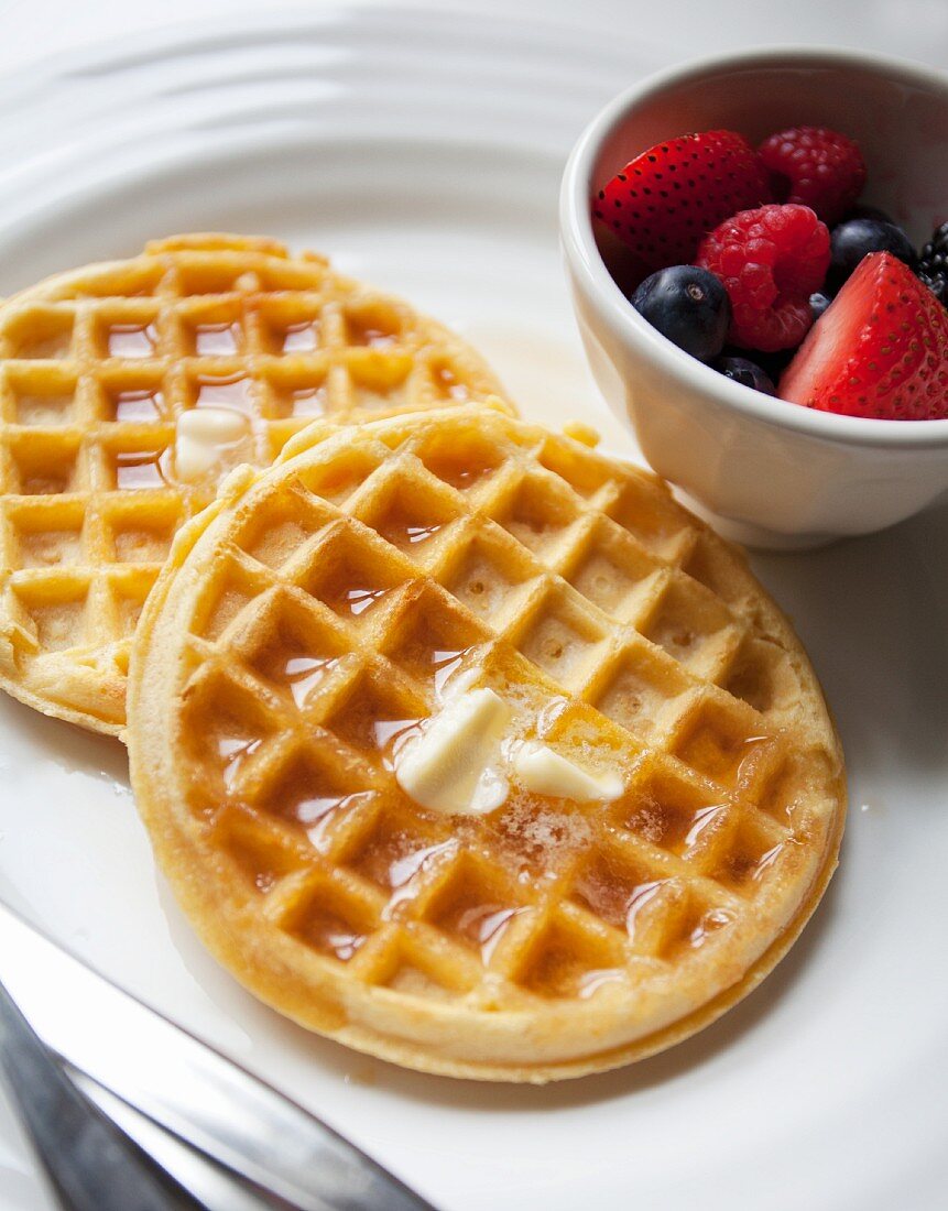 Waffles with butter, maple syrup and berries