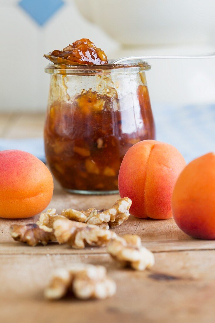 A jar of apricot and nectarine jam with walnuts