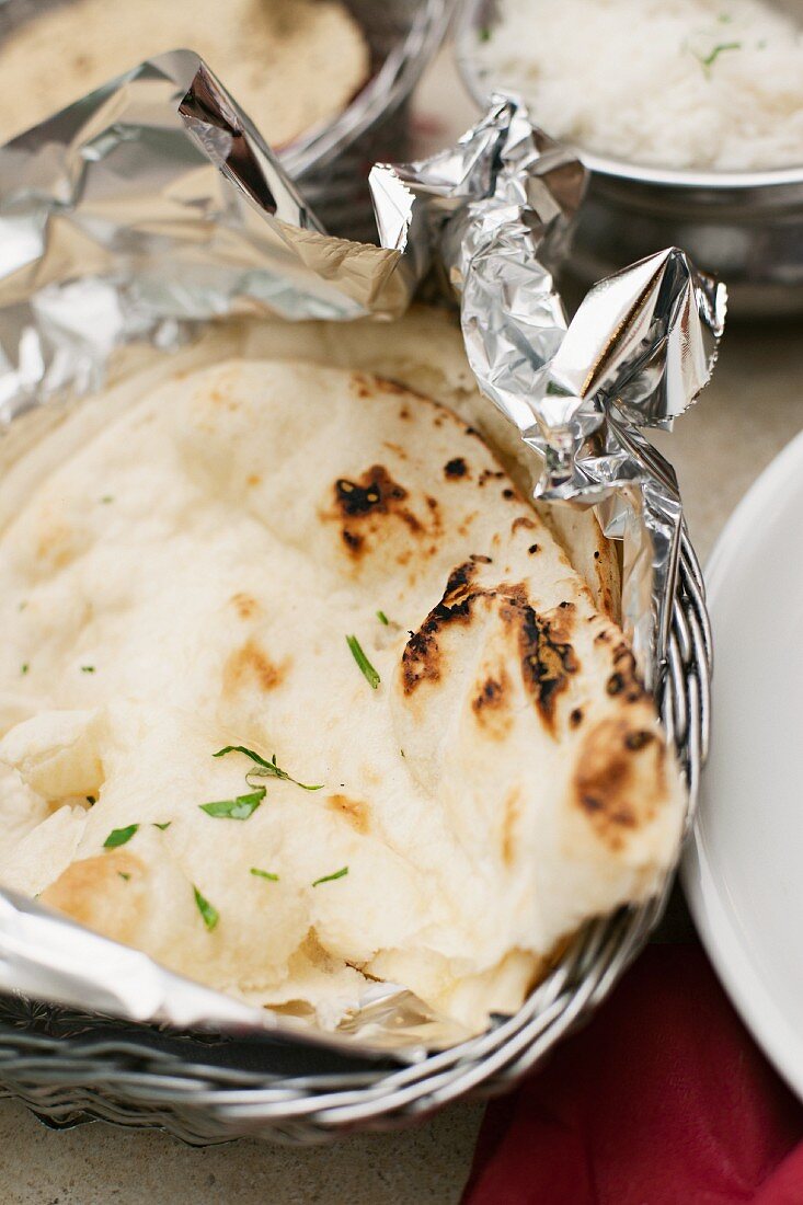 Naan bread in tin foil in a breadbasket