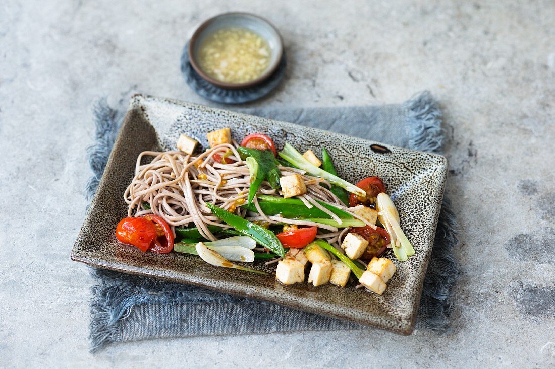 Oriental noodles with tofu, mange tout and tomatoes