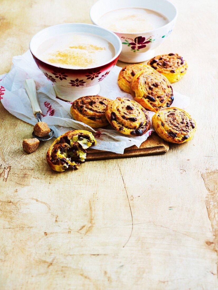 Cinnamon buns with chocolate almonds and two cups of cafe latte