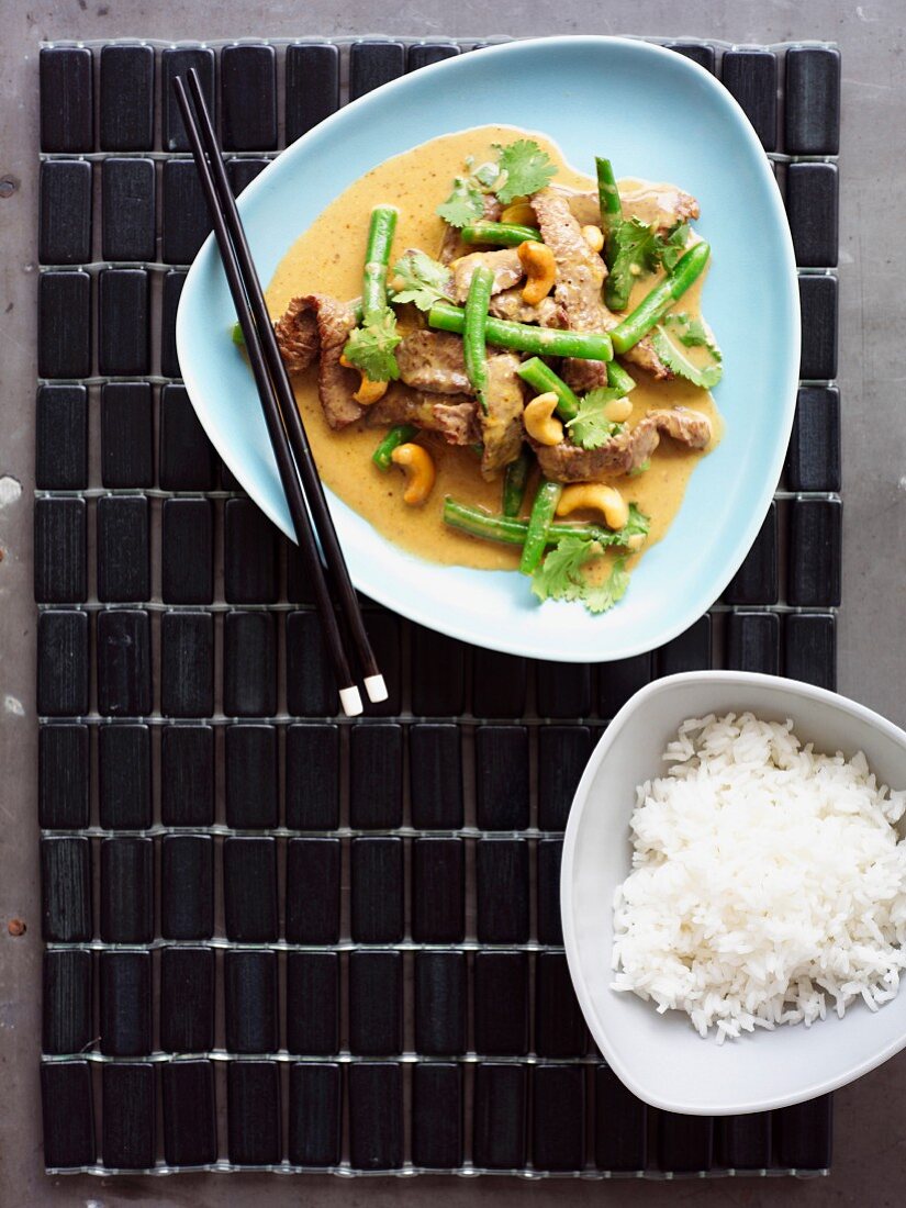 Rindfleisch in Kokossauce mit Cashews, grünen Bohnen und Reisbeilage (Asien)