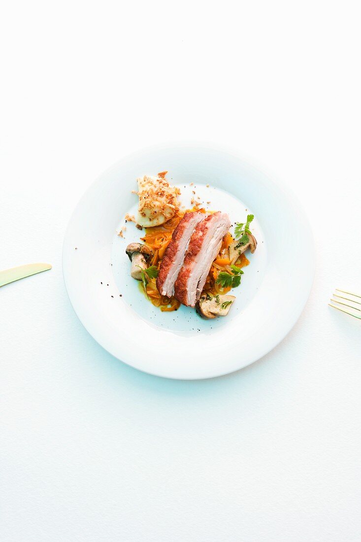 Roast free range pork on a vegetable salad with mushrooms