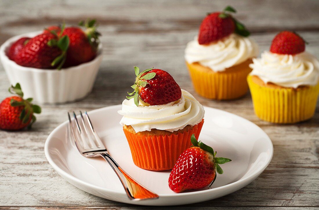 Strawberry cupcakes topped with cream
