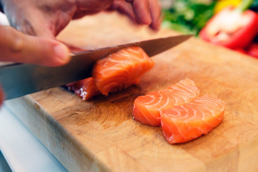 Roher Lachs wird in Stücke geschnitten