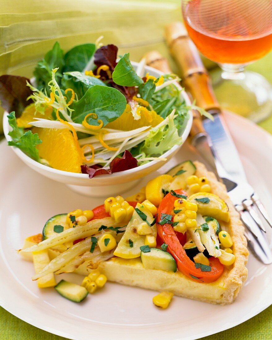 A slice of vegetable tart with salad