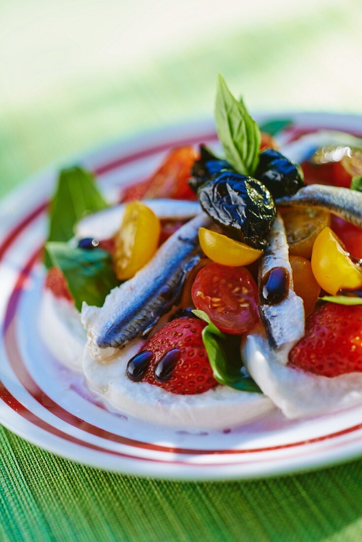 Mozzarella salad with anchovies, strawberries and cherry tomatoes