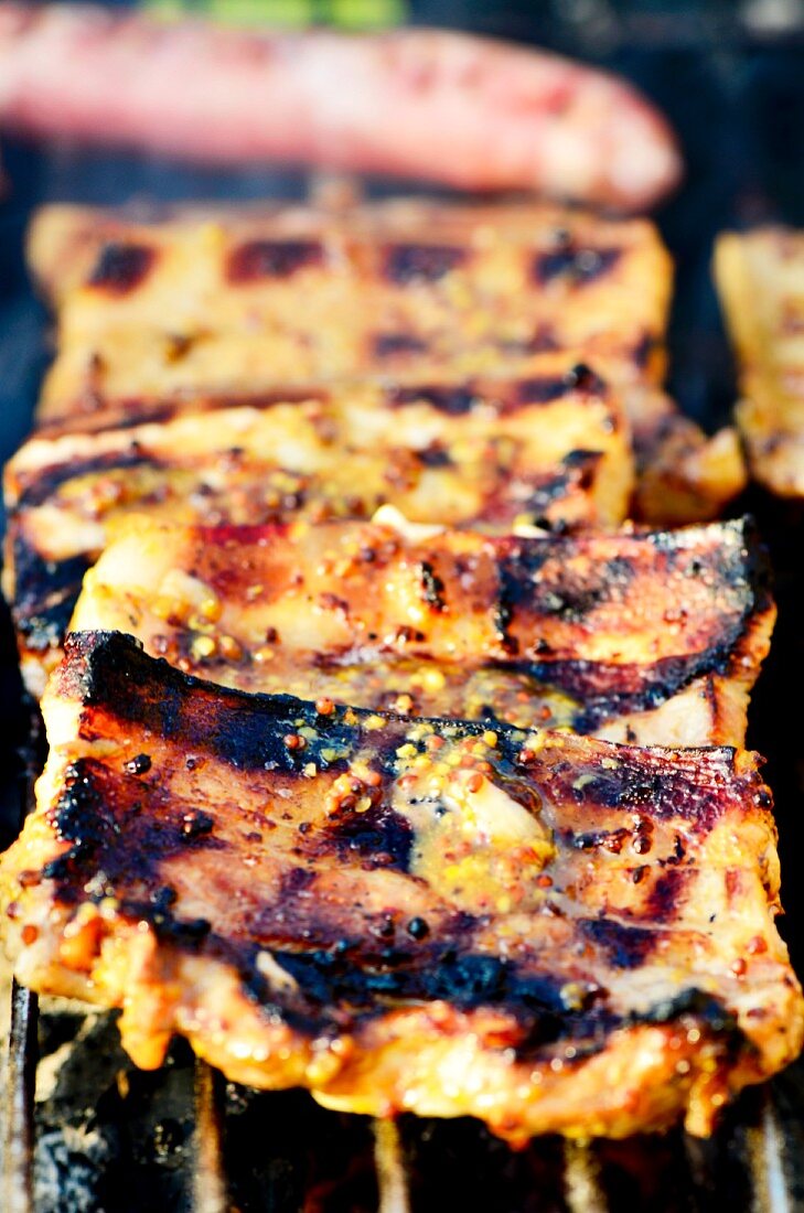 Pork belly marinated in a honey and mustard marinade on a barbecue