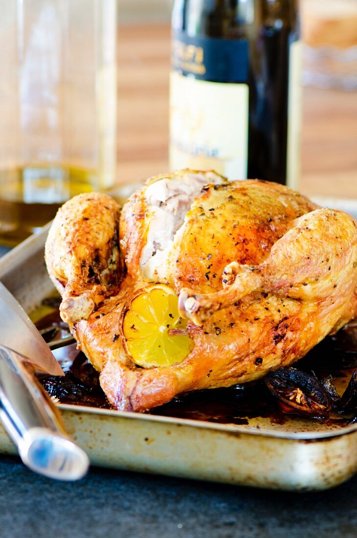 Roast chicken with lemons in a roasting tin