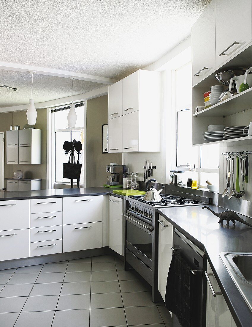 L-shaped counter in modern kitchen with white cabinets and tiled floor