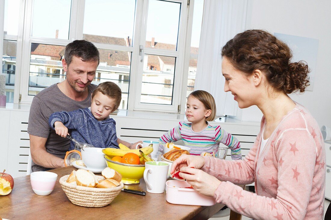 Vierköpfige Familie isst gesundes Frühstück