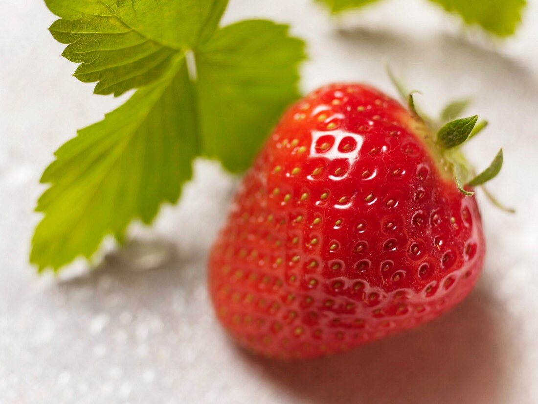 A strawberry with a leaf (close-up)