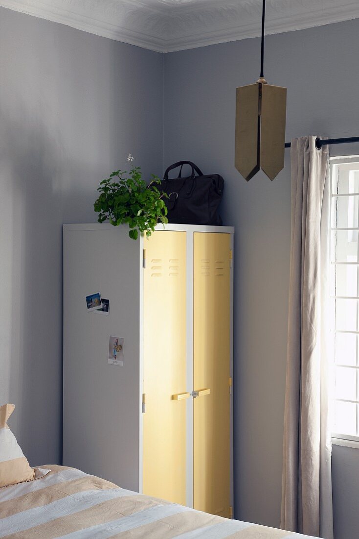 Weisser Spind mit pastellgelben Türen als Vintage Schrank im Schlafzimmer