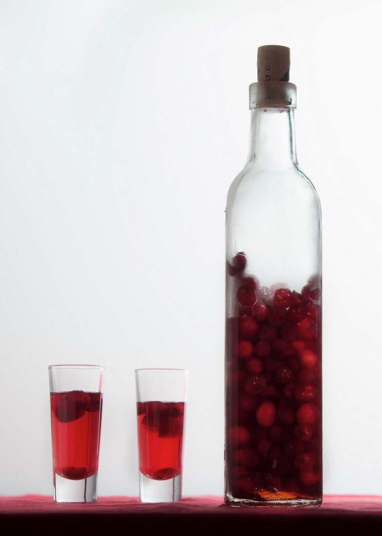 Homemade cherry liqueur in a bottle and in shot glasses