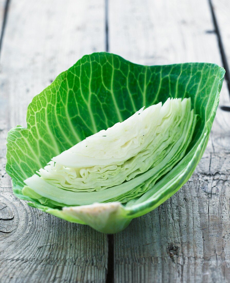 A wedge of white cabbage in a white cabbage leaf