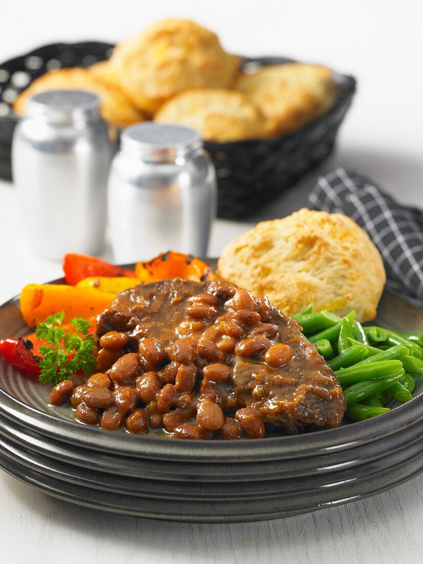 Beef steak with a bean sauce, roasted peppers and green beans