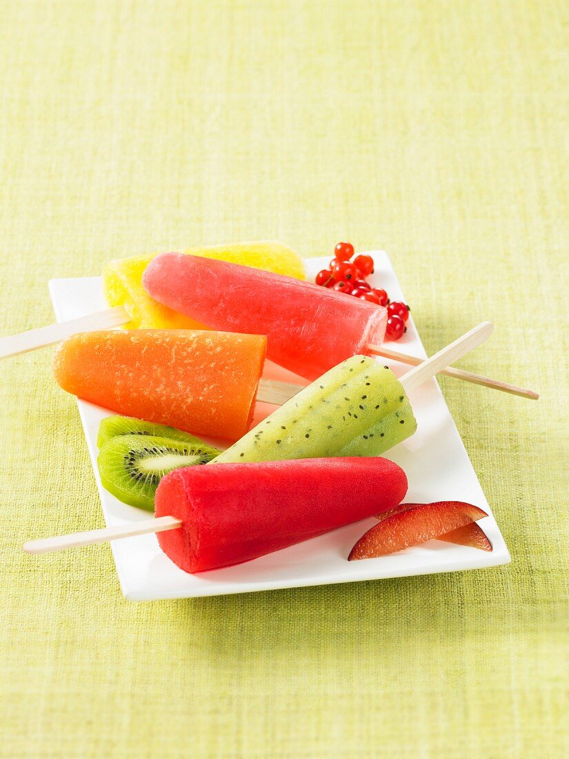 Colourful homemade fruit ice lollies on a square plate