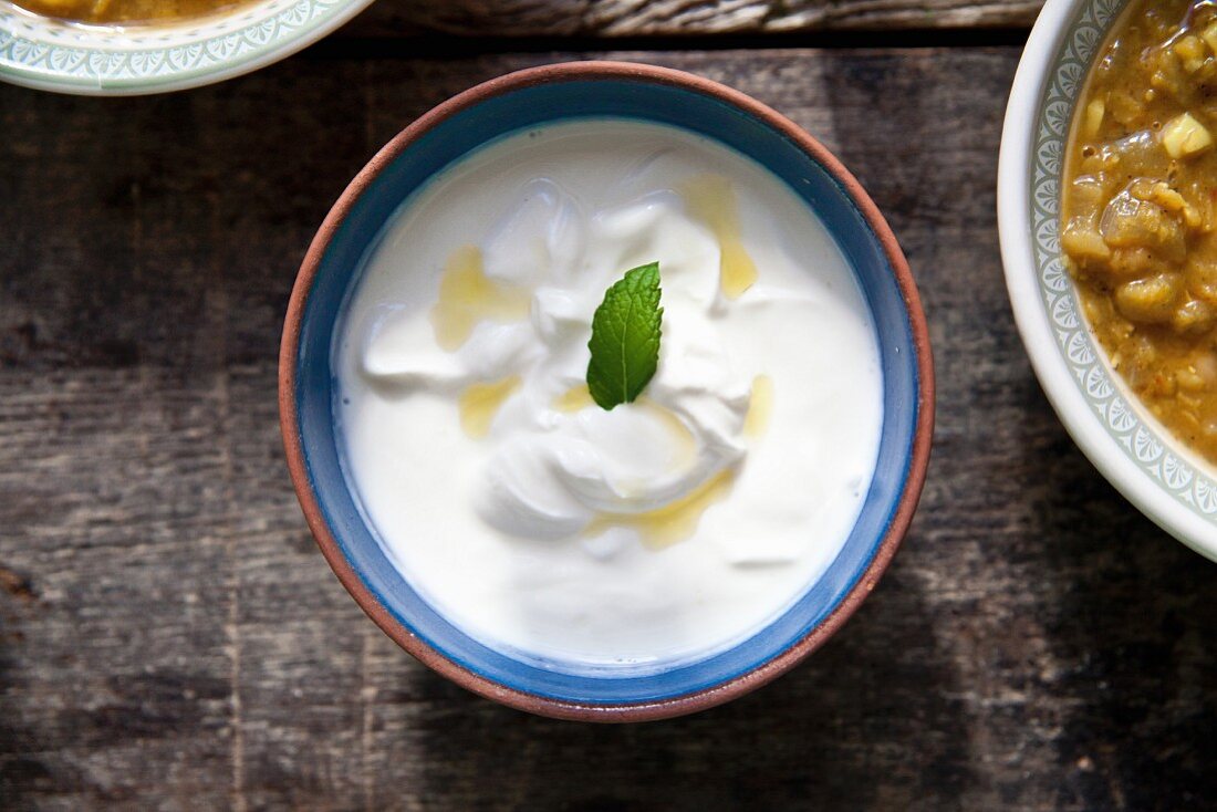 Raita with a mint leaf in a ceramic bowl