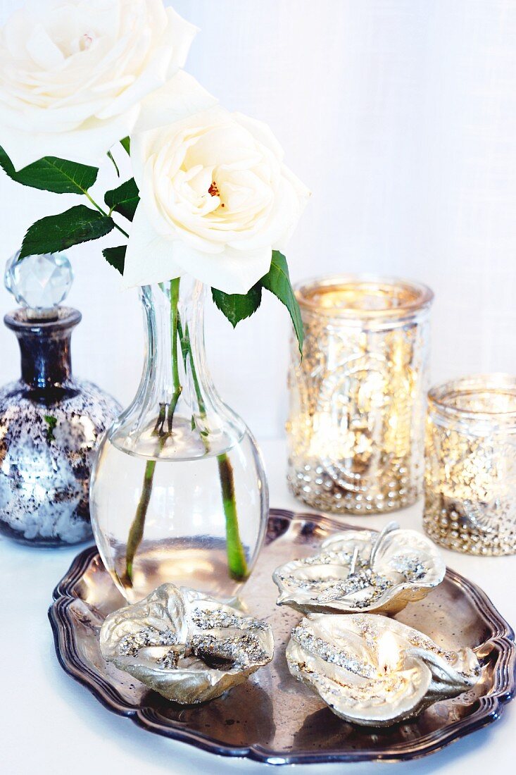 Leaf-shaped dishes and vase of white roses on silver tray