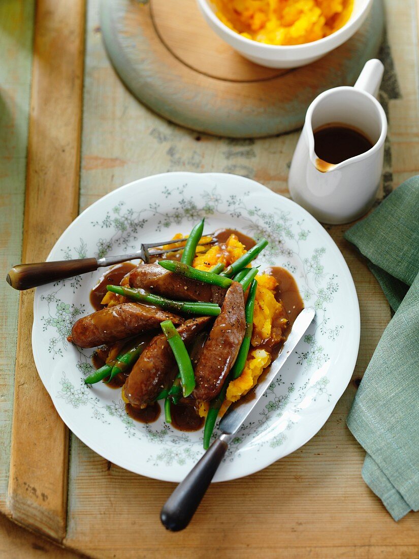 Sausages with mashed potatoes and pumpkin, green beans and gravy