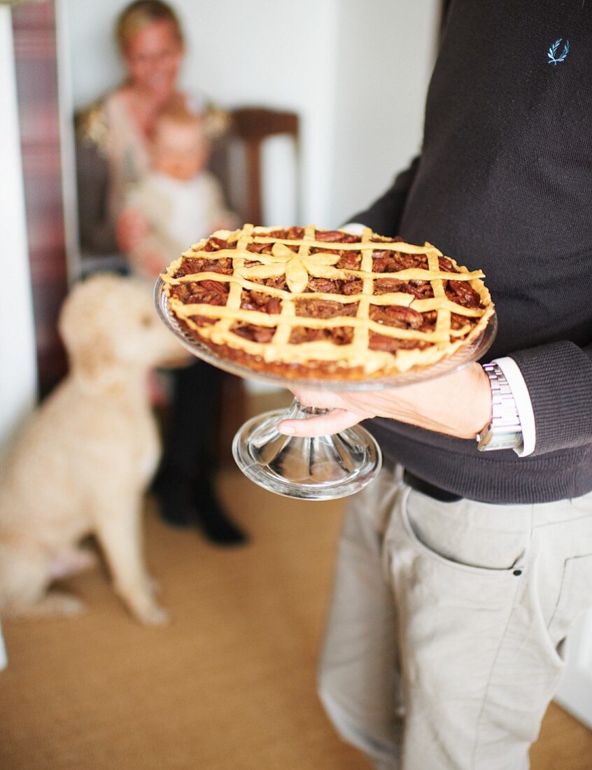 Mann serviert Kuchenplatte mit Pecanpie zu Thanksgiving