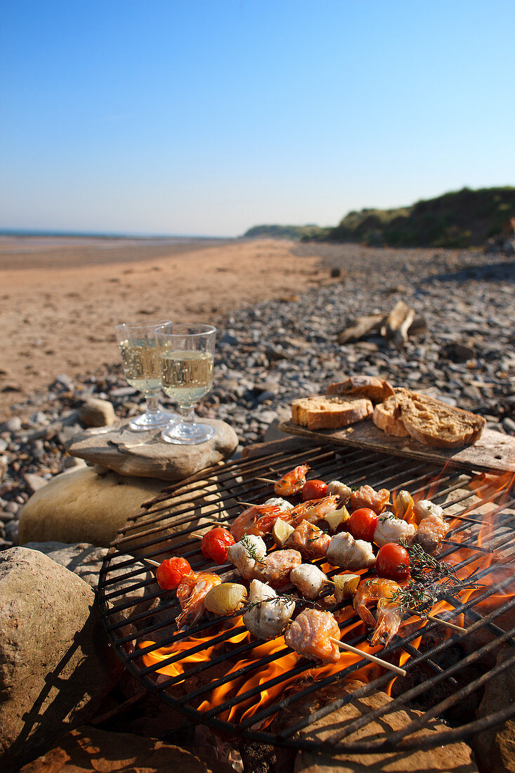 Fish skewers on a barbecue on a beach