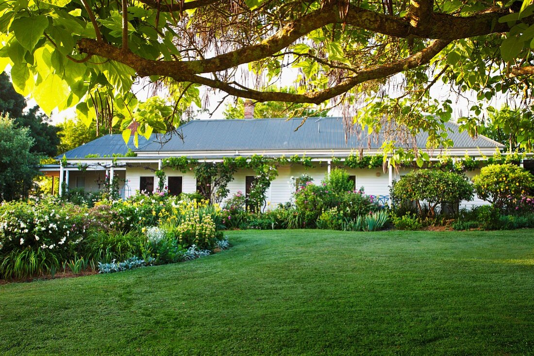 Broad lawn in front of elongated Canadian country house