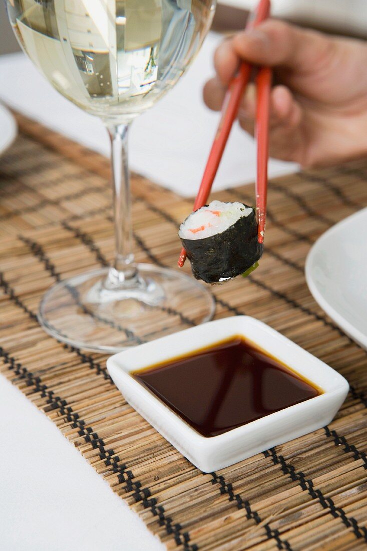 Maki-Sushi, Sojasauce und ein Glas Wein
