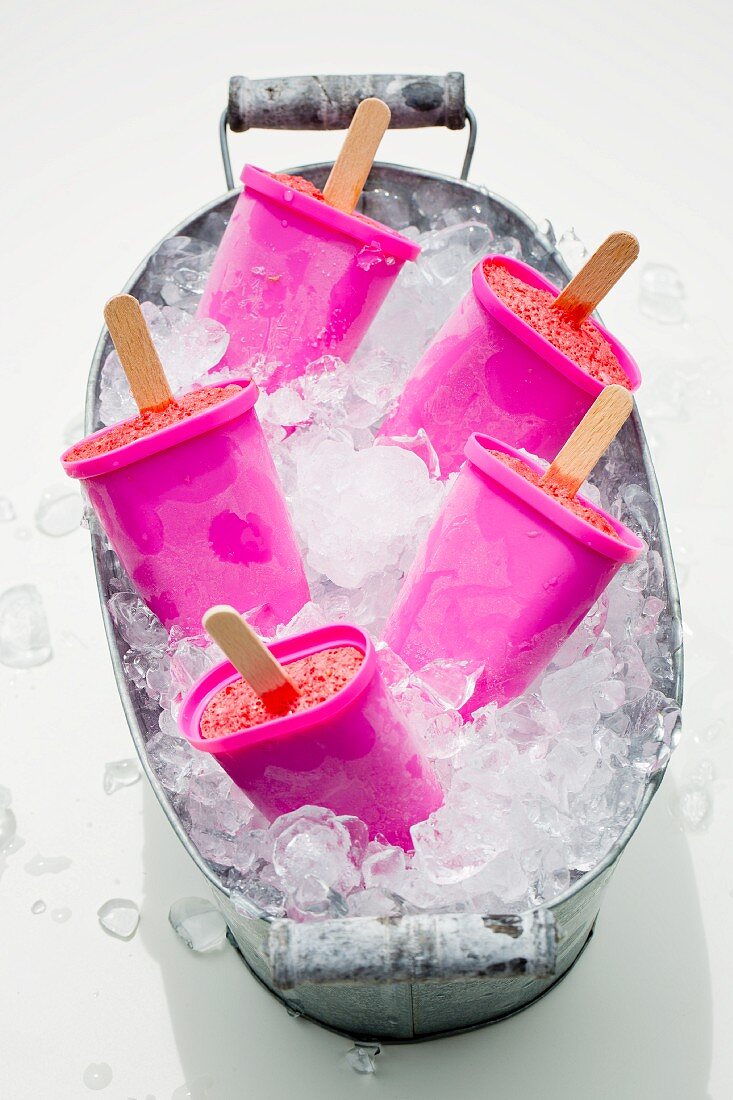 A zinc tub filled with crushed ice and five ice lolly makers
