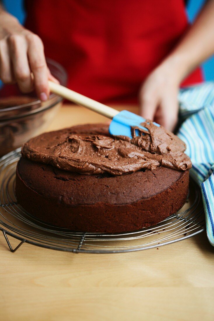 Schokoladenkuchen mit Creme bestreichen