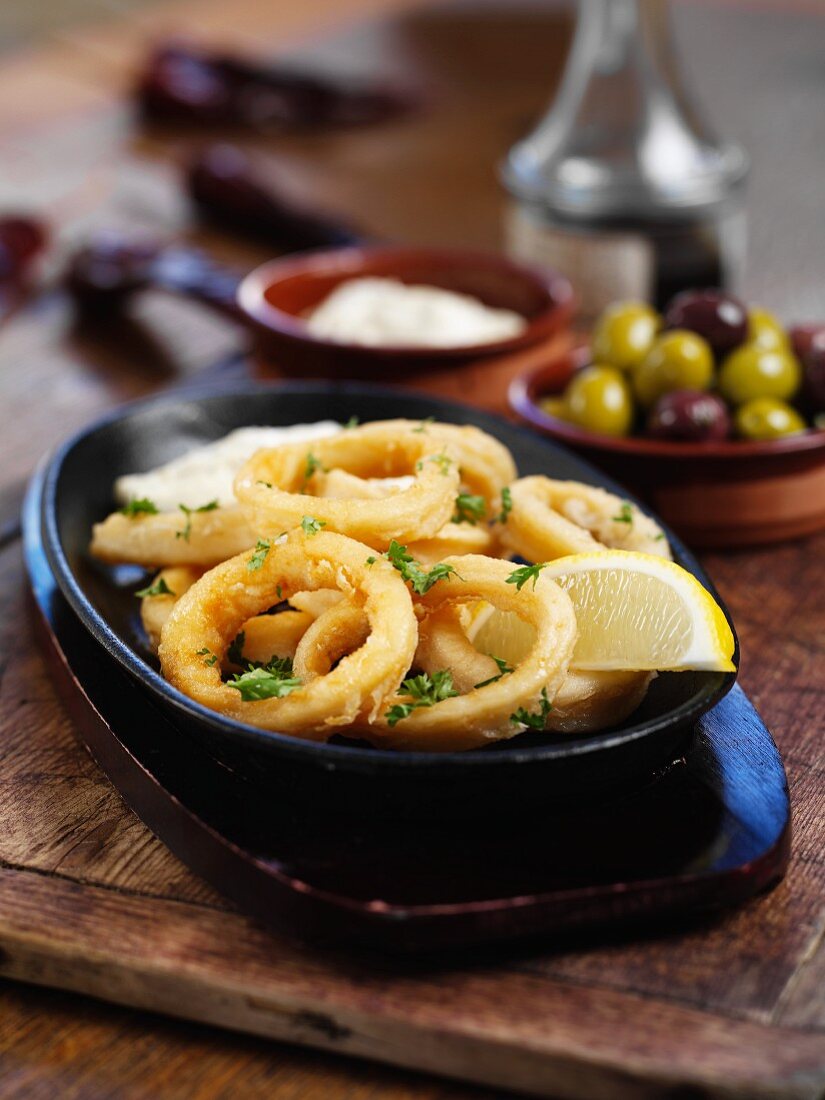 Fried squid rings with lemons and olives (Spain)
