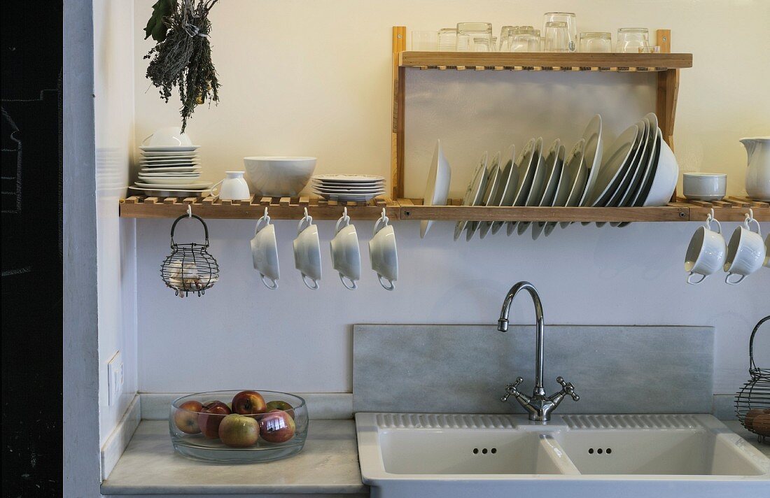 Crockery on wooden draining rack above sink