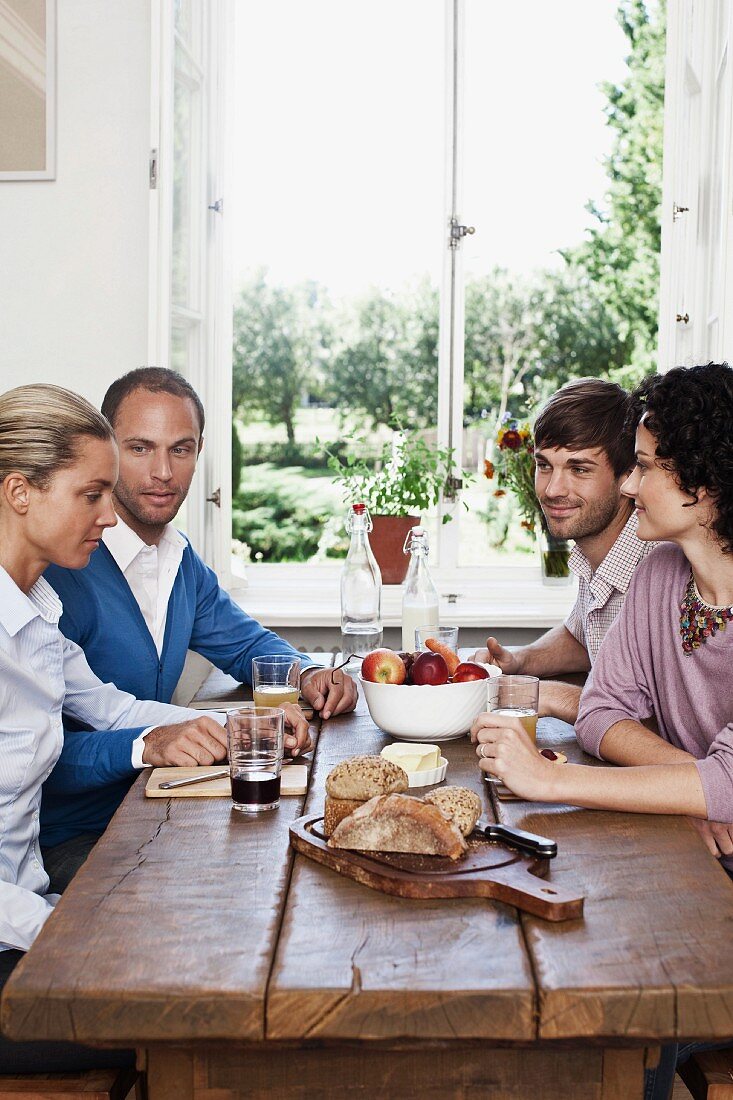 Two couples sitting at a dinning table together