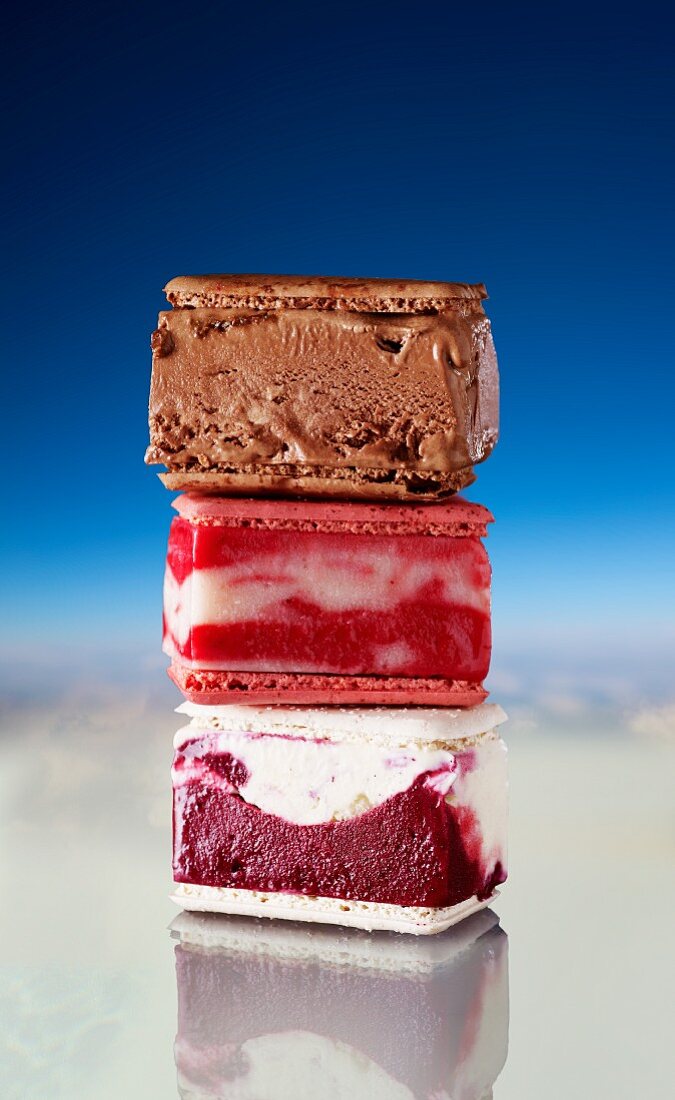 A stack of ice cream sandwiches: chocolate, strawberry and cassis