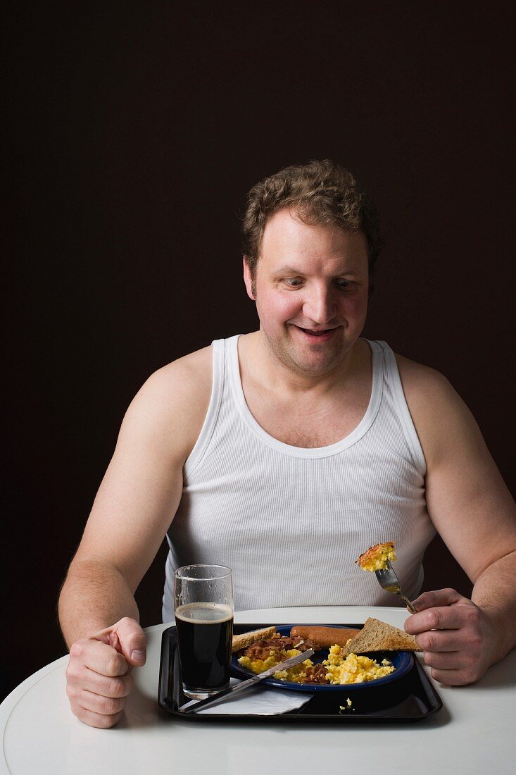 A stereotypical Englishman eating an English breakfast