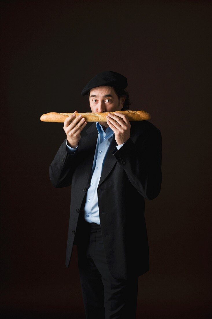 A stereotypical Frenchman sniffing a baguette