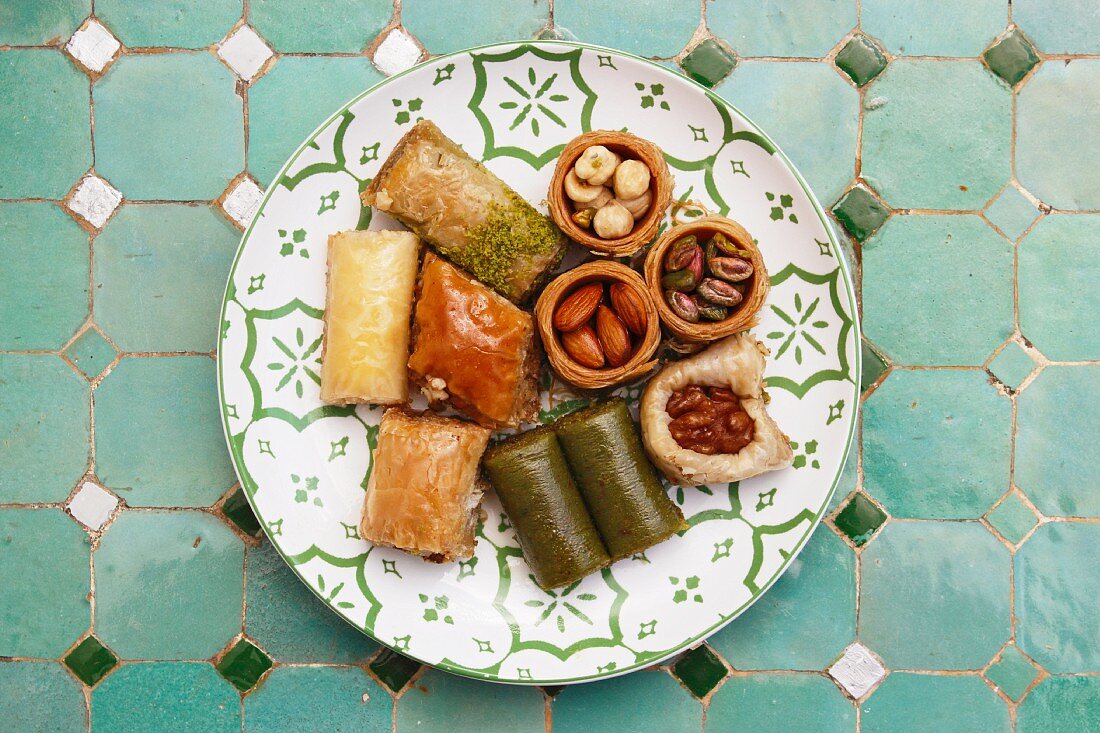 Various baklava and Turkish nut cakes on a ceramic plate