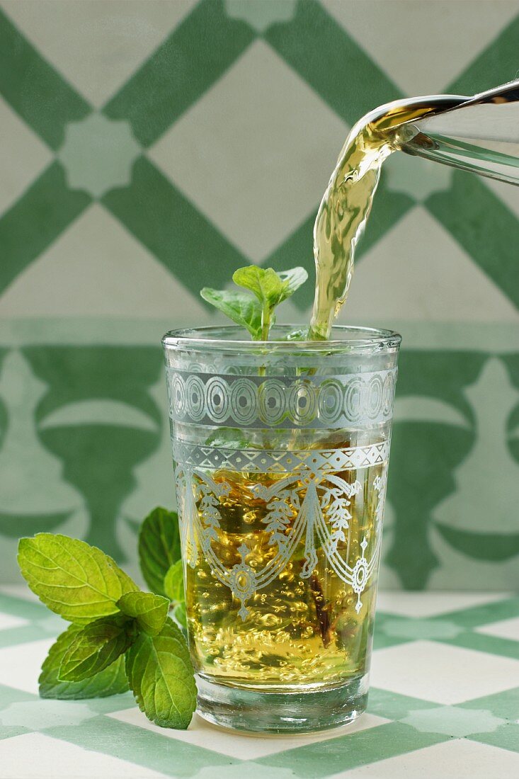 Peppermint tea being poured into a glass