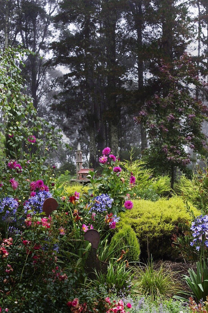 Flowering garden with architectural sculpture in background