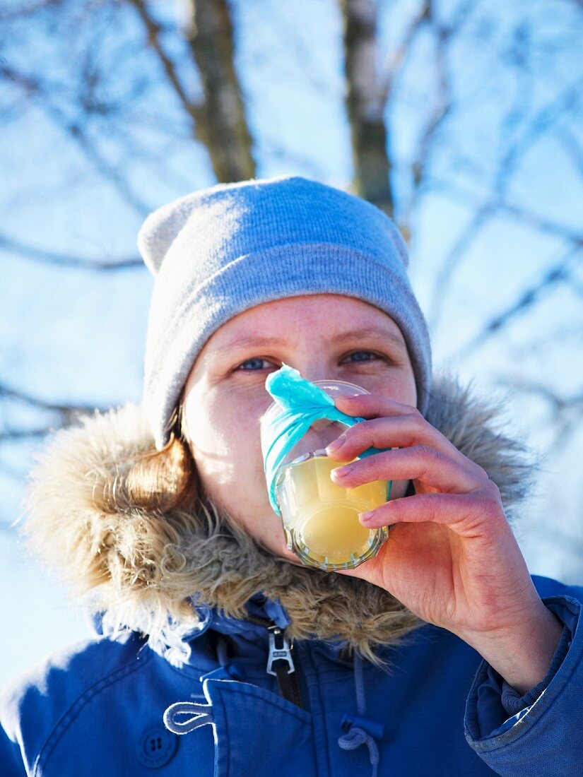 Frau trinkt heiße Limonade beim Winterpicknick